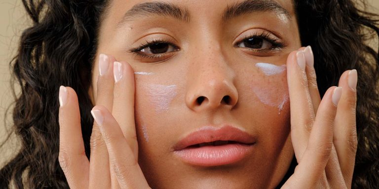 Femme qui s'applique de la crème sur le visage