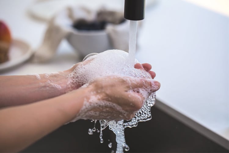 personne qui a du savon dans les mains