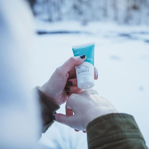 femme qui s'applique de la crème pour les mains