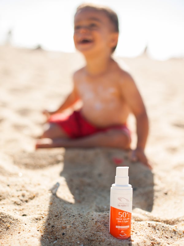 Enfant à la plage avec de la crème solaire