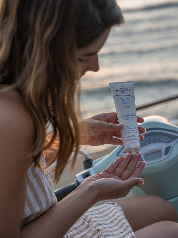 Femme qui s'applique du fluide après-soleil bio des Laboratoires de Biarritz