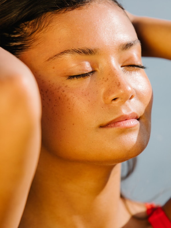 Soleil qui rayonne sur le visage d'une jeune femme