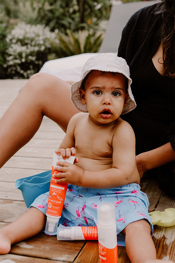 bébé au bord de la piscine avec une crème solaire
