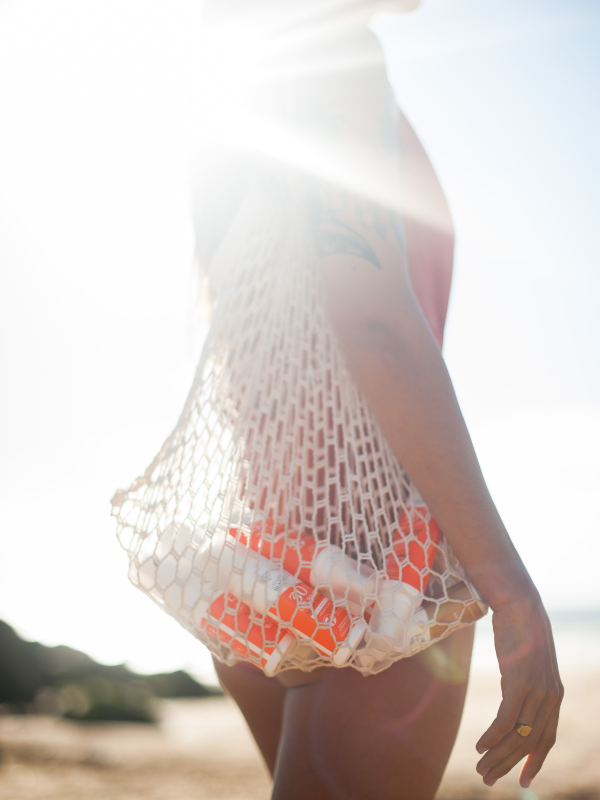 Femme à la plage avec ses produits solaires