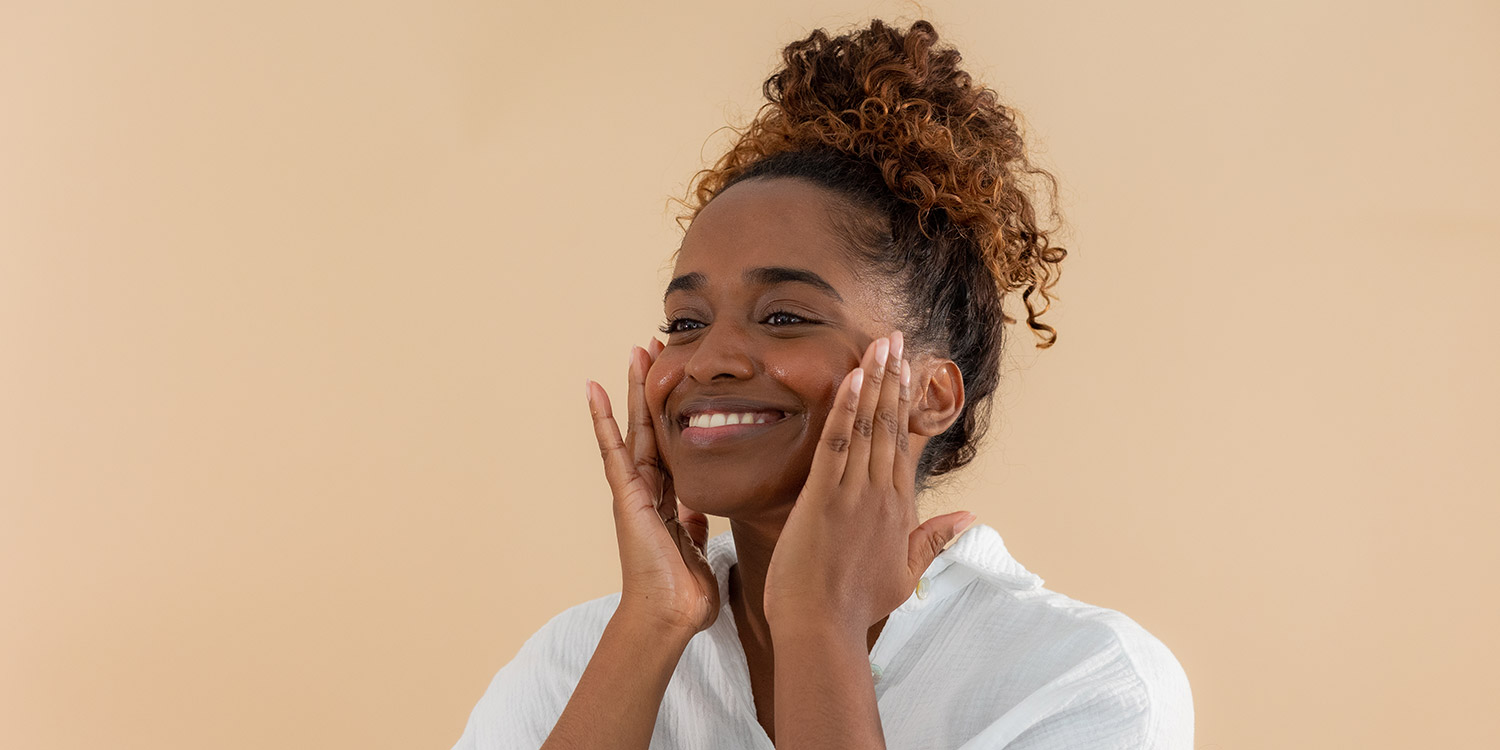 Femme qui se nettoie le visage avec une huile démaquillante